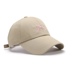 Beige baseball cap with pink bow embroidery shown from a 45-degree side angle