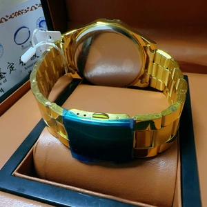 Detail of gold-plated metal watch band with secure clasp and stainless steel back case