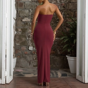 Detail of burgundy ruched tube dress showing slim fit back and backless design on model