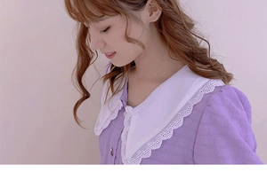 Detail of elegant lavender jacquard fabric with delicate white double-layered lace collar