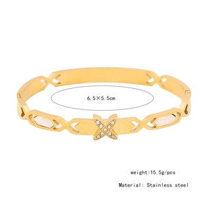 Dettaglio del bracciale dorato in acciaio inossidabile con design a X e piccoli cristalli