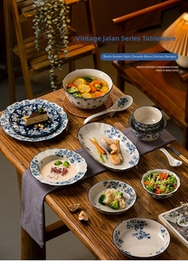 Detail of vintage blue floral ceramic dinnerware set served on a wooden dining table