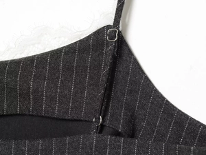 Dettaglio del tessuto a righe grigio nero con pizzo bianco e spallina regolabile