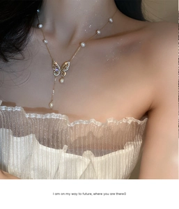 Detailed view of gold-plated butterfly necklace with fresh water pearls and zircons