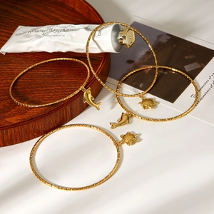 Detailansicht von vier 18k Gold Armbändern mit Delphin- und Seesternanhängern für Damen