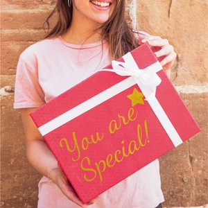 Close-up of red textured gift box with You are Special! text and white satin ribbon