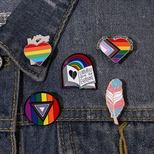 Regenbogen Emaille Pins Set auf Jeansjacke mit Herz- und Buchdesign Motiven