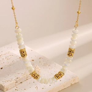 Detailed close-up of gold-plated beads and white pearls on a stylish layered necklace