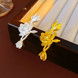 Detail of flower earrings in silver and gold metal finish on a luxury jewelry box