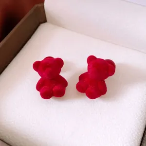 Elegant red flocked acrylic bear stud earrings presented in a luxury jewelry box