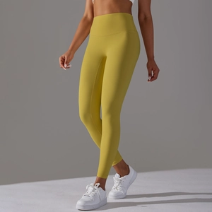 Detail view of mustard yellow high-waisted yoga pants with seamless stretch fabric