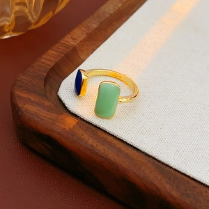 Detail of adjustable gold ring with deep blue and light green enamel rectangle accents