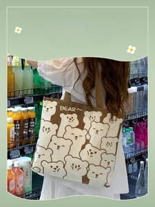 Detail of canvas shoulder bag showing cute cartoon bear patterns and large capacity