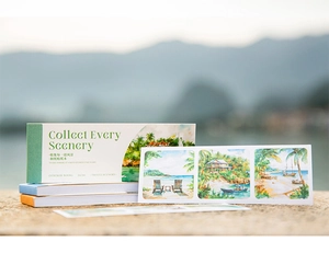 Macro view of travel-themed washi paper sticker book with watercolor coastal scenery art