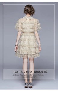 Detailed back view of beige lace layered cake dress with ruffle trim and high density mesh