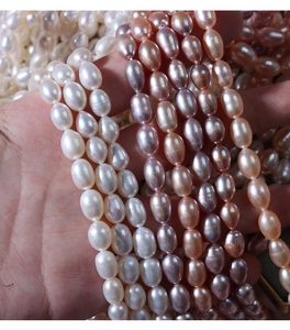 Macro shot of 5-6mm white and pink oval freshwater pearls showing high luster and texture
