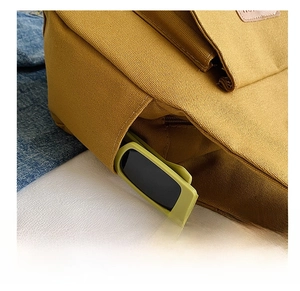 Detail view of khaki canvas tote with functional side pocket and leather logo patch