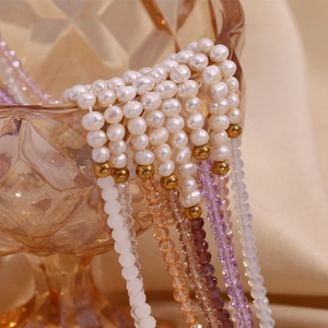 Detailed close-up of freshwater pearls and faceted crystal beads on a golden chain