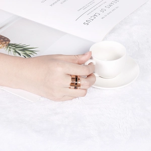 Chic rose gold and black titanium steel ring with Roman numerals on a hand