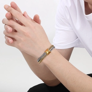 Close-up of dual-tone gold and silver fish-scale chain bracelet on a model's wrist