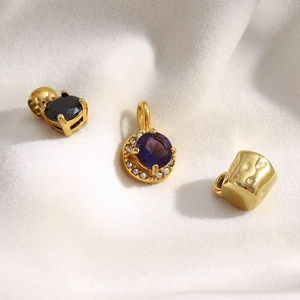 Detailed view of 18K gold-plated stainless steel pendants with black and purple zircons