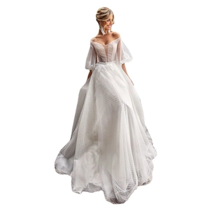 Robe de mariée blanche à épaules dénudées avec manches bouffantes et dentelle à pois