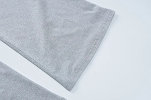Dettaglio del tessuto a maglia grigio chiaro con cuciture piatte a doppio ago