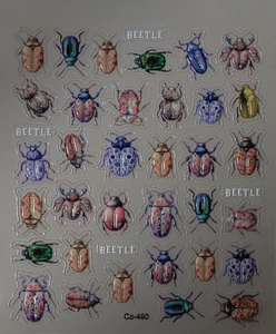 Detail showing beetle nail art stickers with porcelain patterns and metallic finish