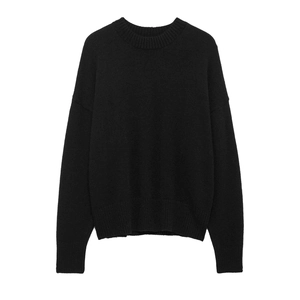 Detailed view of black crewneck knit sweater with ribbed cuffs and drop shoulder texture