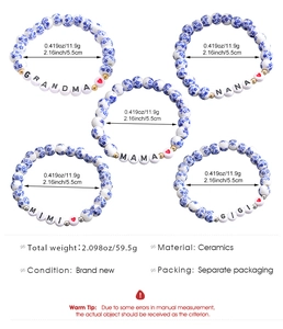 Dettaglio di bracciali in ceramica bianca e blu con ciondoli Grandma Nana Mama Mimi e Gigi