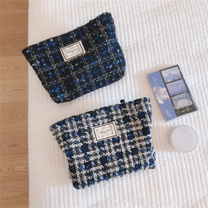 Close-up of blue tweed makeup bags with zipper closure and Time to Party patch