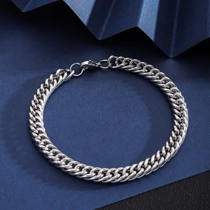 Classic silver Cuban link stainless steel bracelet with lobster clasp on dark background