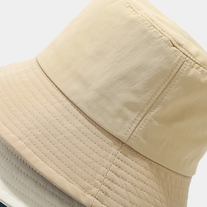 Detail view of reinforced stitching on brim of light beige quick-dry bucket hat