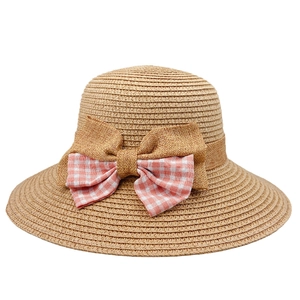 Women's woven straw sun hat with a decorative pink plaid bow on white background