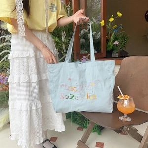 Détail du sac cabas en toile bleu clair avec broderie Lucky Sazikka et motifs étoiles