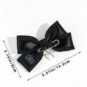 Detailed view of gothic black satin bow hair clip with silver cross pendants and size markings