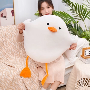Close-up of a large white plush duck toy held by a model to showcase its size and soft fur