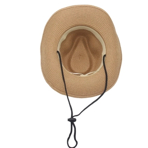 Handmade raffia straw sun hat with adjustable black wind cord on a white background