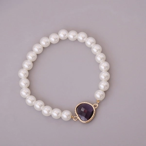 Elegant white pearl bracelet with a deep purple heart gemstone and gold frame detail