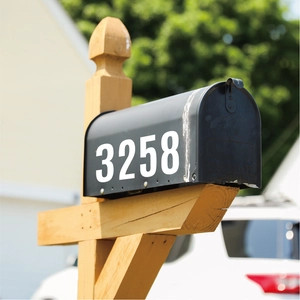 Outdoor white reflective mailbox stickers showing number 3258 on a black letterbox