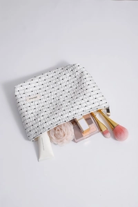 Dettaglio della trousse per trucco a pois con pennelli e cosmetici all'interno