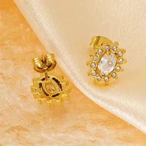 Elegant gold sunflower stud earrings with zircon crystals on champagne silk background