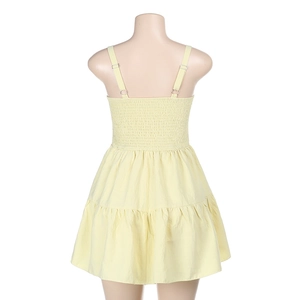 Détail de robe jaune clair avec dos élastique froncé et ourlet à volants superposés