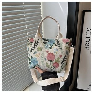 Detailed view of beige floral tote bag with adjustable strap and colorful prints