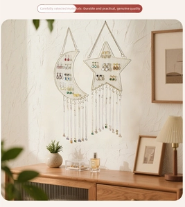 Detail of moon and star wall jewelry rack with gold metal mesh and hanging hooks
