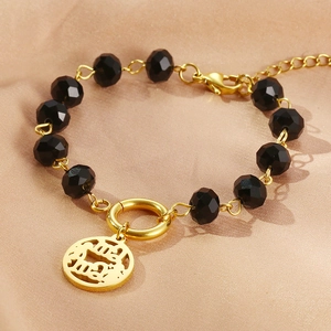 Retro gold chain bracelet with black crystals and a round mama pendant on champagne silk
