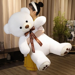 Close-up of oversized white plush teddy bear with Just for you ribbon and heart paw detail