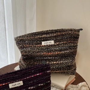 Detail of wool tweed pouches featuring colorful woven lines and pom-pom textures