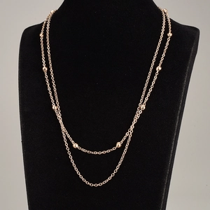 Detailed view of layered rose gold titanium steel necklace on a black jewelry bust