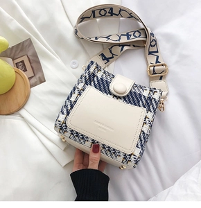 Detail of tweed and leather patchwork shoulder bag with jacquard wide strap on white shirt